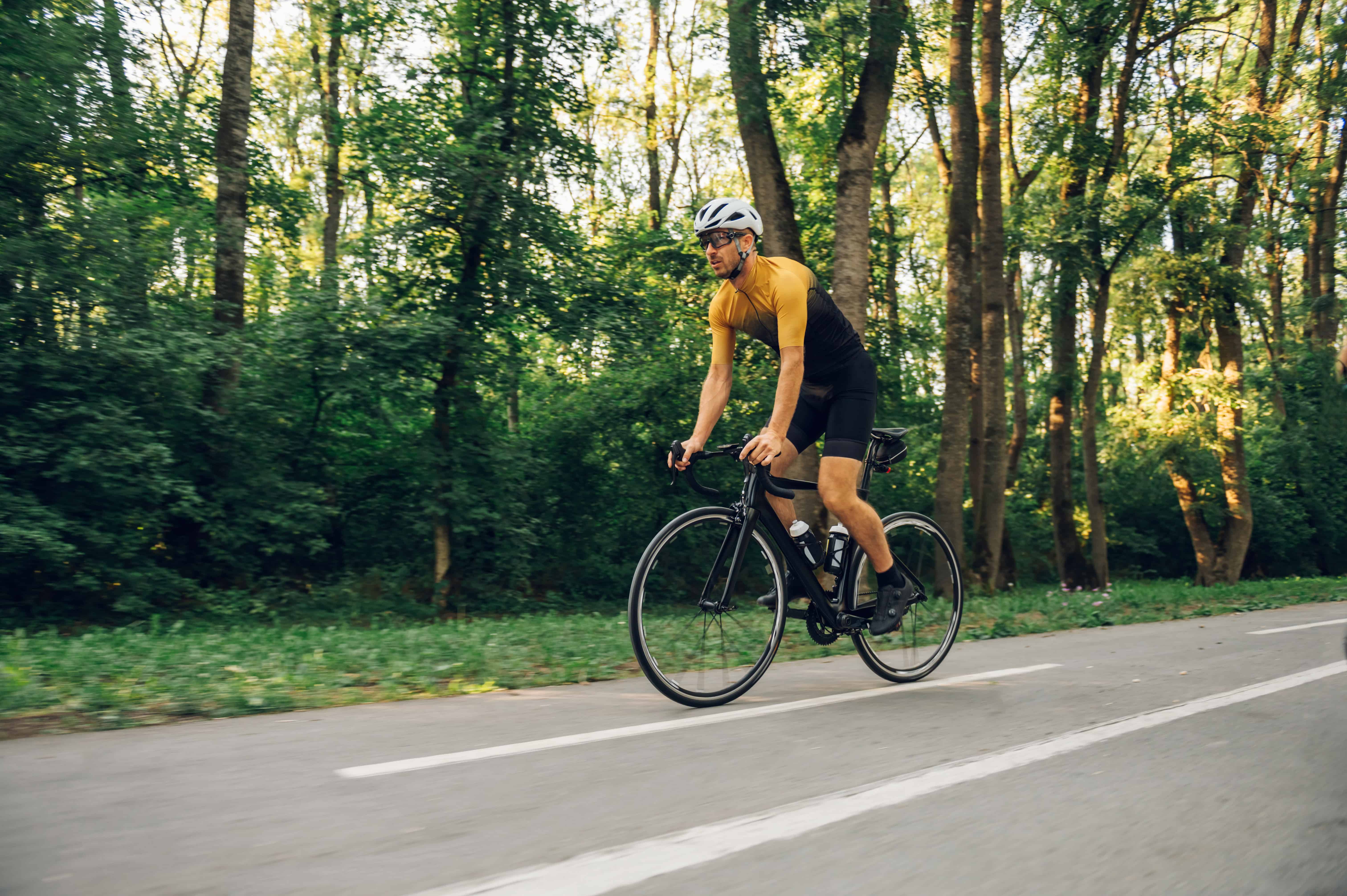 Athletic man in sport clothes riding a bike in the nature